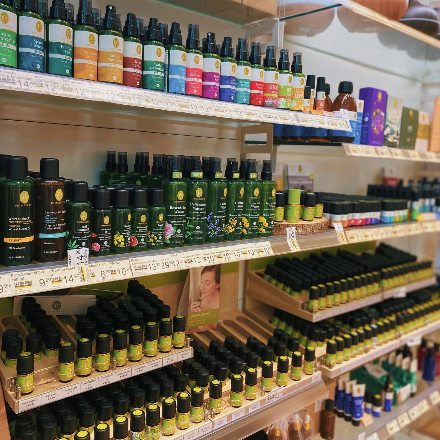 Regal mit zahlreichen Fläschchen naturreiner ätherischer Öle und Raumsprays